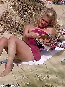 A mature woman feels that she is not being watched on a beach for nudists.