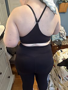 A woman in the nude is riding a horse and wearing a cowgirl hat.